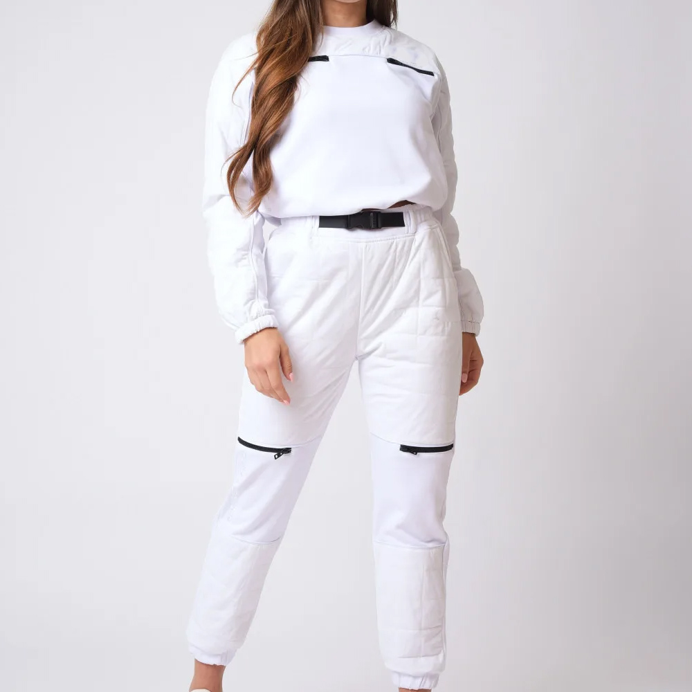 Female model wearing a premium white cotton drill cargo tracksuits with utility pockets and buckle belt.